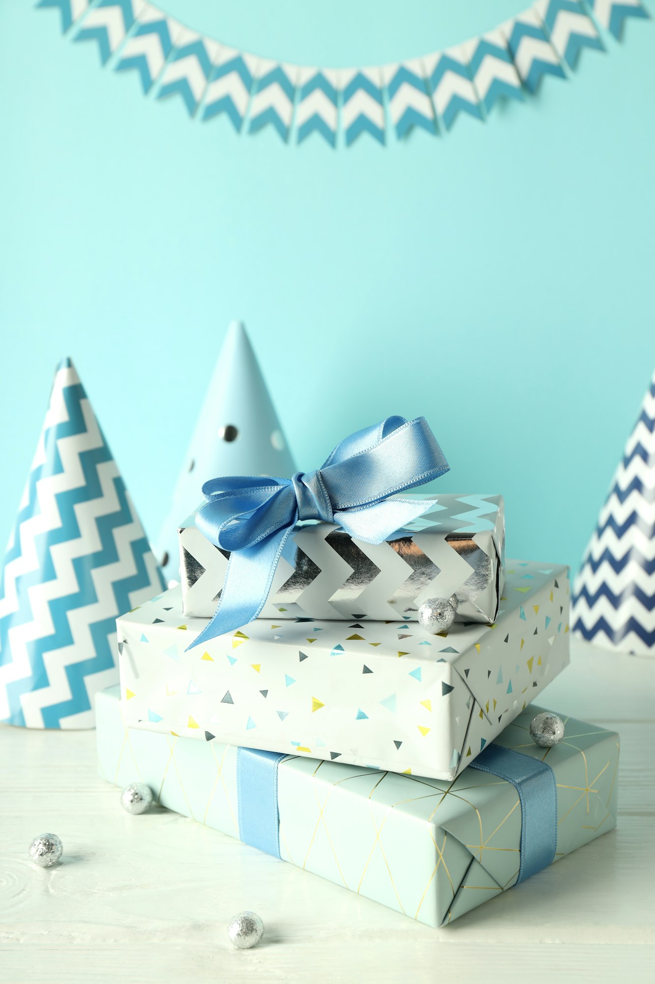 Birthday accessories on white wooden table against blue background