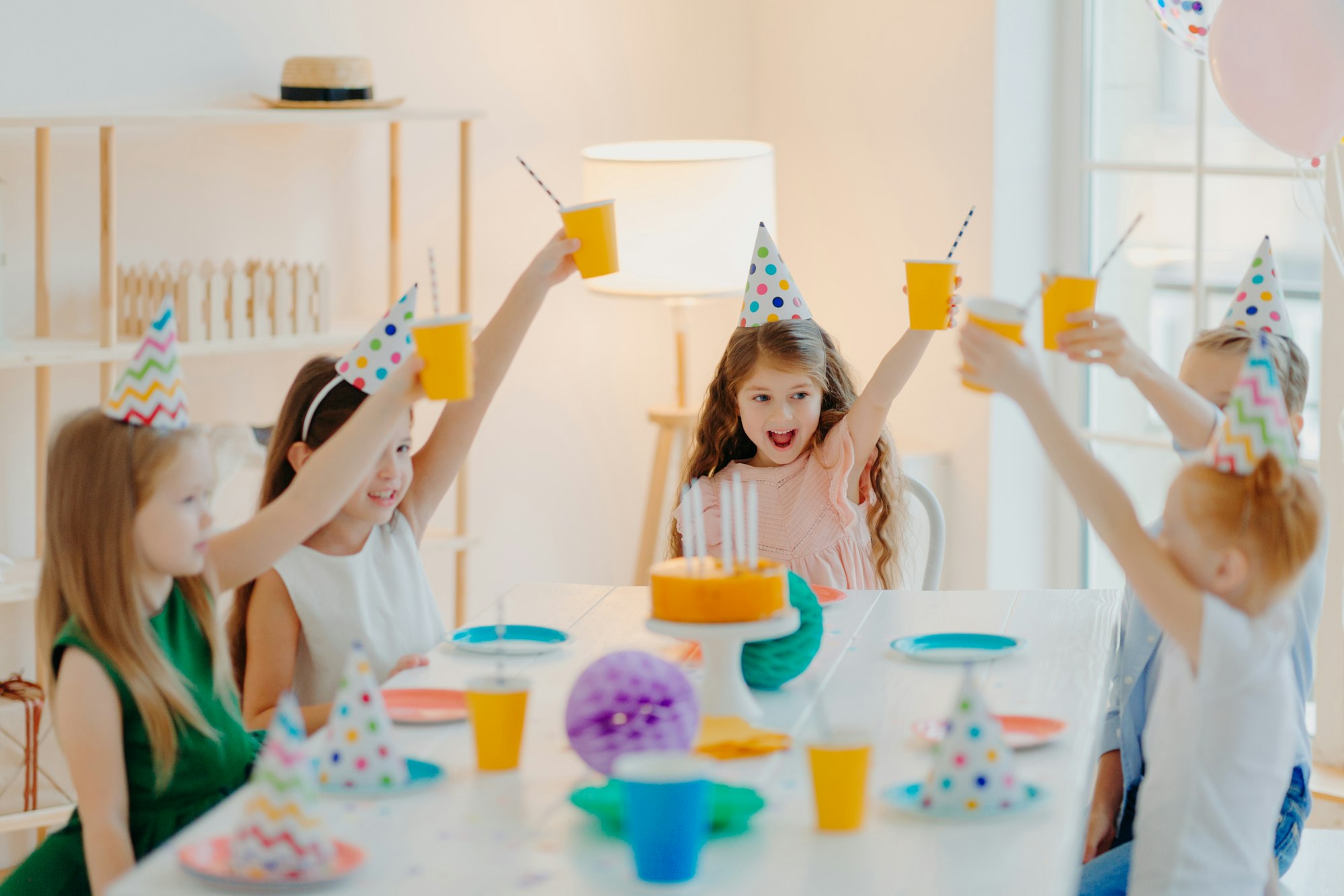 Group of cheerful preschool kids celebrate birthday together, have fun